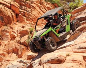 2017.arctic-cat.wildcat-trail.black-and-green.front-left.riding.down-rocks.jpg